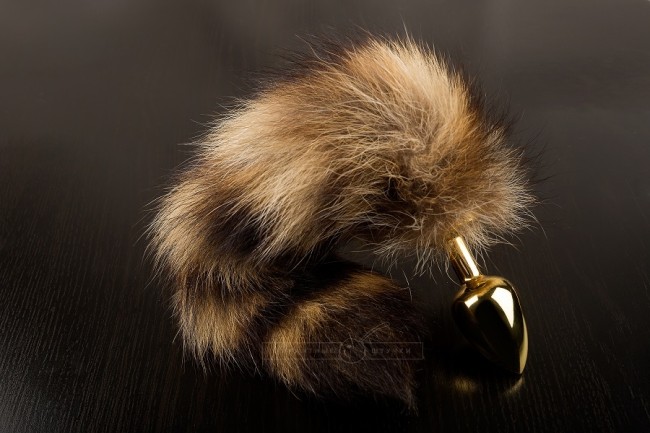 Маленькая золотистая пробка с хвостом енота 